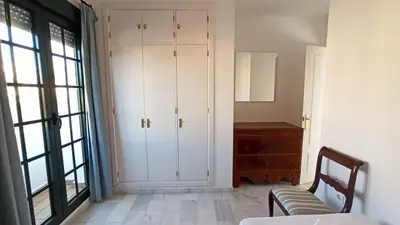 a bedroom with white cabinets and a bed and a dresser at Villa Mar de Las Redes in El Puerto de Santa María