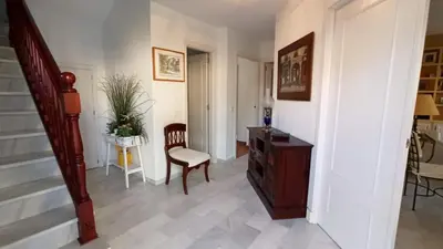 a hallway with a chair and a table and stairs at Villa Mar de Las Redes in El Puerto de Santa María
