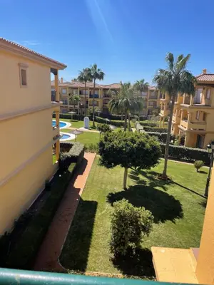 a view of a yard with palm trees and buildings at Margaritas 27 in Chiclana de la Frontera