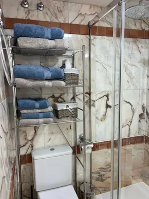 a bathroom with a shower with a toilet and towels at Margaritas 27 in Chiclana de la Frontera