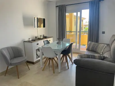 a living room with a glass table and chairs at Margaritas 27 in Chiclana de la Frontera
