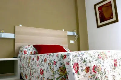 a bedroom with a bed with a floral bedspread at Mi UNIVERSO in San Fernando