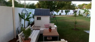 a backyard with a dog house and a table at Casa Pelicano in Chiclana de la Frontera