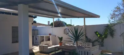 a patio with a table and a fence at Casa Pelicano in Chiclana de la Frontera