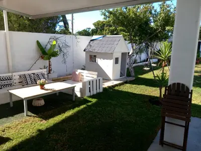 a small backyard with a table and a dog house at Casa Pelicano in Chiclana de la Frontera