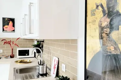 a kitchen with a sink and a painting of a woman at Casa Dionisio - Súper central y tranquilo con terraza y parking in Jerez de la Frontera
