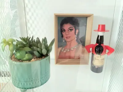 a bottle of wine next to a picture of a woman at Casa Dionisio - Súper central y tranquilo con terraza y parking in Jerez de la Frontera
