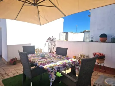 a table with chairs and an umbrella on a patio at Casa Dionisio - Súper central y tranquilo con terraza y parking in Jerez de la Frontera