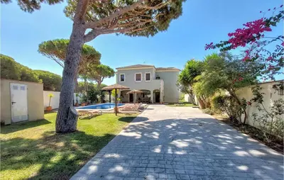 a driveway leading to a villa with a tree at Gorgeous Home In Conil De La Frontera in Conil de la Frontera