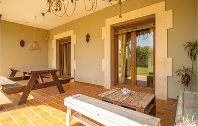 a patio with a wooden table and a bench at Gorgeous Home In Conil De La Frontera in Conil de la Frontera