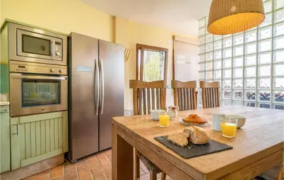 a kitchen with a table with bread and a refrigerator at Gorgeous Home In Conil De La Frontera in Conil de la Frontera