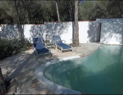 two blue chairs sitting next to a swimming pool at Casa Palmito in Chiclana de la Frontera