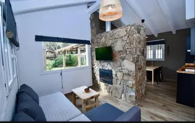 a living room with a stone fireplace and a couch at Casa Palmito in Chiclana de la Frontera