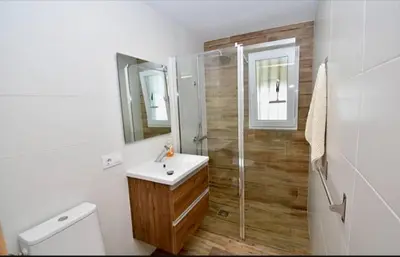 a white bathroom with a sink and a shower at Casa Palmito in Chiclana de la Frontera