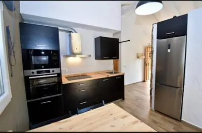 a kitchen with black cabinets and a black refrigerator at Casa Palmito in Chiclana de la Frontera