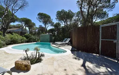 a small swimming pool in a backyard with a fence at Casa Palmito 2 in Chiclana de la Frontera