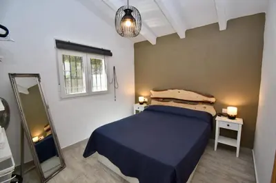 a bedroom with a blue bed and a mirror at Casa Palmito 2 in Chiclana de la Frontera