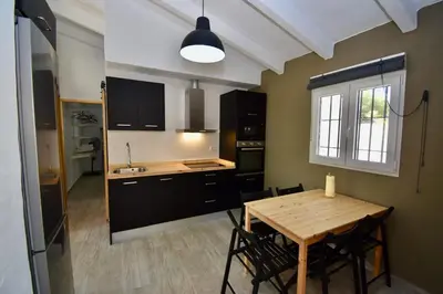 a kitchen with a wooden table and a dining room at Casa Palmito 2 in Chiclana de la Frontera