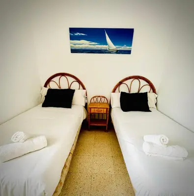two beds in a room with a sailboat on the wall at MyChoice America in Rota
