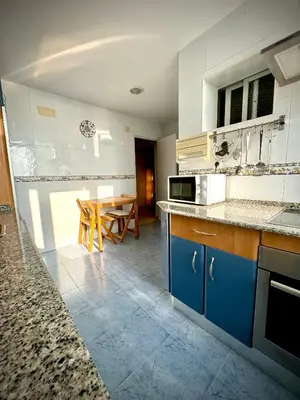 a kitchen with blue cabinets and a table in it at MyChoice America in Rota