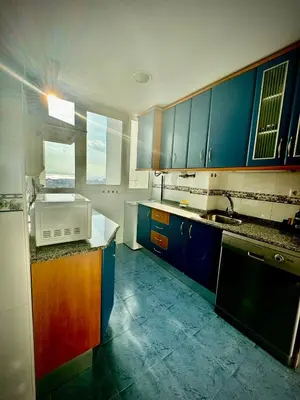 a large kitchen with blue cabinets and a sink at MyChoice America in Rota