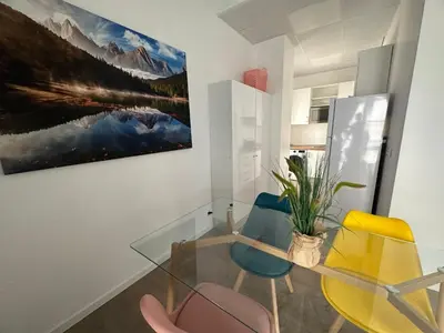 a dining room with a glass table and chairs at Apartamento Nebro Sol, En el Corazón de Cádiz in Cádiz