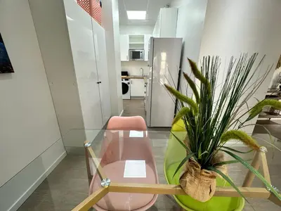 a room with a pink chair and a potted plant at Apartamento Nebro Sol, En el Corazón de Cádiz in Cádiz