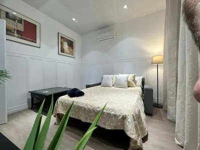 a bedroom with a bed and a table with a plant at Apartamento Nebro Sol, En el Corazón de Cádiz in Cádiz