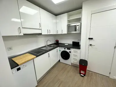 a kitchen with white cabinets and a sink and a dishwasher at Apartamento Nebro Sol, En el Corazón de Cádiz in Cádiz