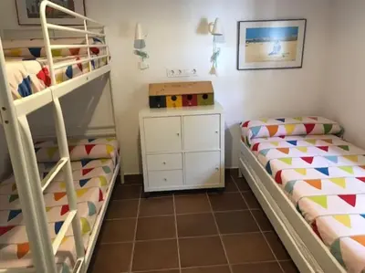 a bedroom with two bunk beds and a desk at El Magnolio in Chiclana de la Frontera