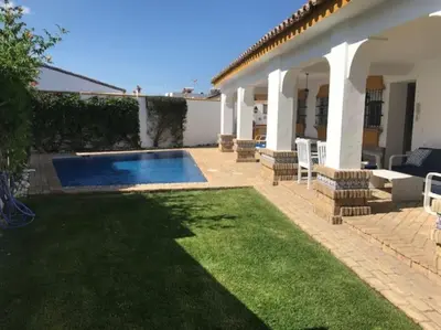 a backyard with a swimming pool and a house at El Magnolio in Chiclana de la Frontera