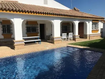 a swimming pool in front of a house at El Magnolio in Chiclana de la Frontera
