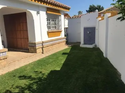 a backyard of a house with a green lawn at El Magnolio in Chiclana de la Frontera
