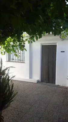 a white building with a door and two windows at Apartamento Barrio Alto in Sanlúcar de Barrameda