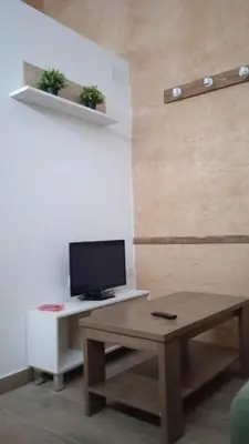 a living room with a desk with a computer on it at Apartamento Barrio Alto in Sanlúcar de Barrameda