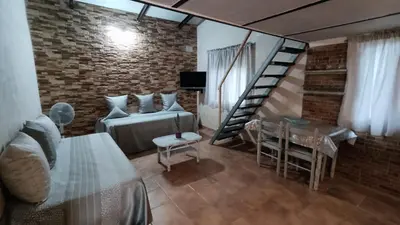a room with a bed and a staircase and a table at La Casa de la Tranquilidad in El Puerto de Santa María