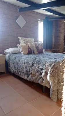 a bed with pillows on it in a bedroom at La Casa de la Tranquilidad in El Puerto de Santa María