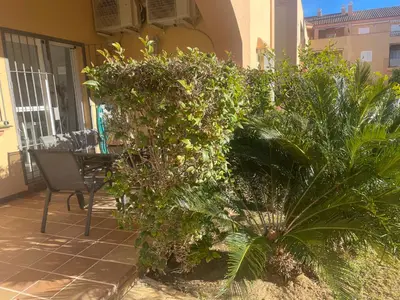 a patio with plants and a table and a chair at Novo Atlantico Golf 7 in Novo Sancti Petri