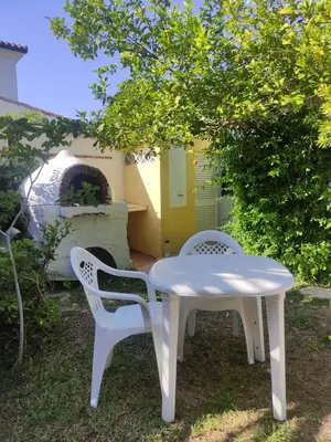 a white table and chairs in a yard with a pizza oven at Sunny Home pool & Garden in Arcos de la Frontera in Arcos de la Frontera