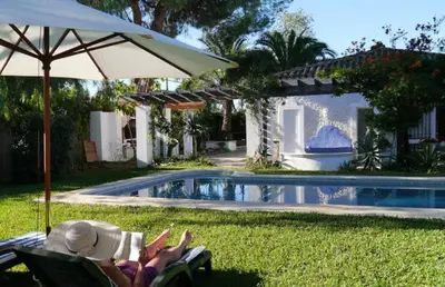 a couple laying in lawn chairs next to a pool at Sunny Home pool & Garden in Arcos de la Frontera in Arcos de la Frontera