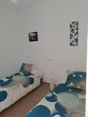 two beds sitting next to each other in a room at Apartamento Irina Sol in Sanlúcar de Barrameda