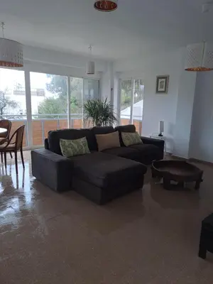 a living room with a black couch and a table at Apartamento Irina Sol in Sanlúcar de Barrameda