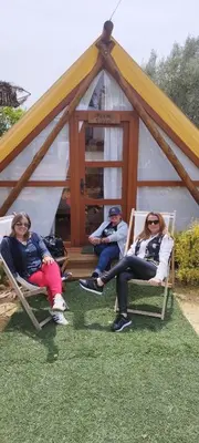 a group of people sitting in chairs in front of a tent at Boho Glamping en Complejo Rural el Mayorazgo in Cádiz