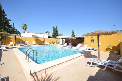 a swimming pool with chairs and a resort at Boho Glamping en Complejo Rural el Mayorazgo in Cádiz