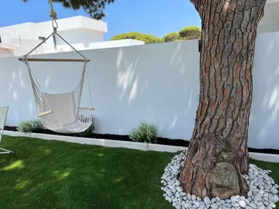 a hammock hanging from a tree in a yard at La casita del sopapo in Chiclana de la Frontera