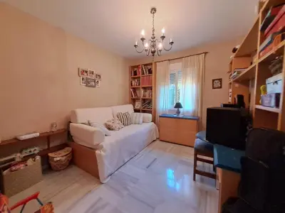 a living room with a white couch and a television at Casa playa El Ancla Puerto Santa María in El Puerto de Santa María