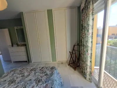 a bedroom with a bed and a dresser and a window at Casa playa El Ancla Puerto Santa María in El Puerto de Santa María