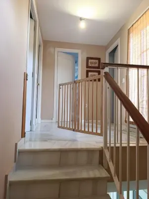 a staircase in a home with a wooden railing at Casa playa El Ancla Puerto Santa María in El Puerto de Santa María
