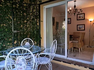 a glass table and chairs on a patio at Casa playa El Ancla Puerto Santa María in El Puerto de Santa María