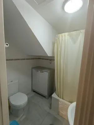 a white bathroom with a toilet and a sink at Casa playa El Ancla Puerto Santa María in El Puerto de Santa María